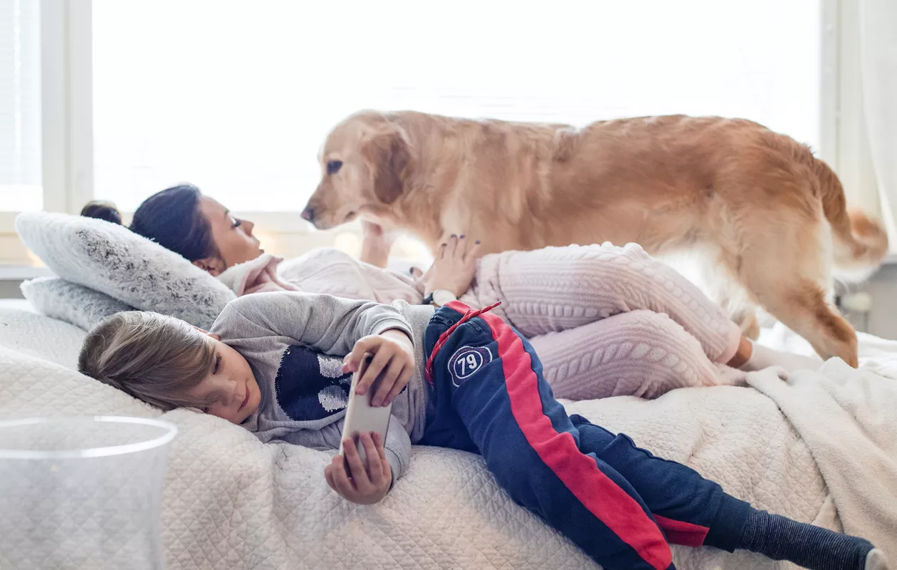 Köyhyysrajalla eläminen: Joa, Emma ja Dara-koira lepäilevät olohuoneen sängyllä.