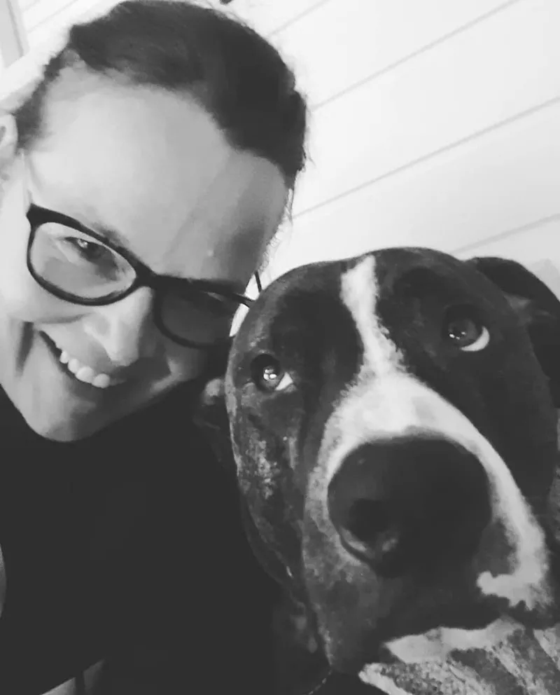 Selfiessä Riikka Sundberg hymyilemässä Jefe-koiran vieressä.