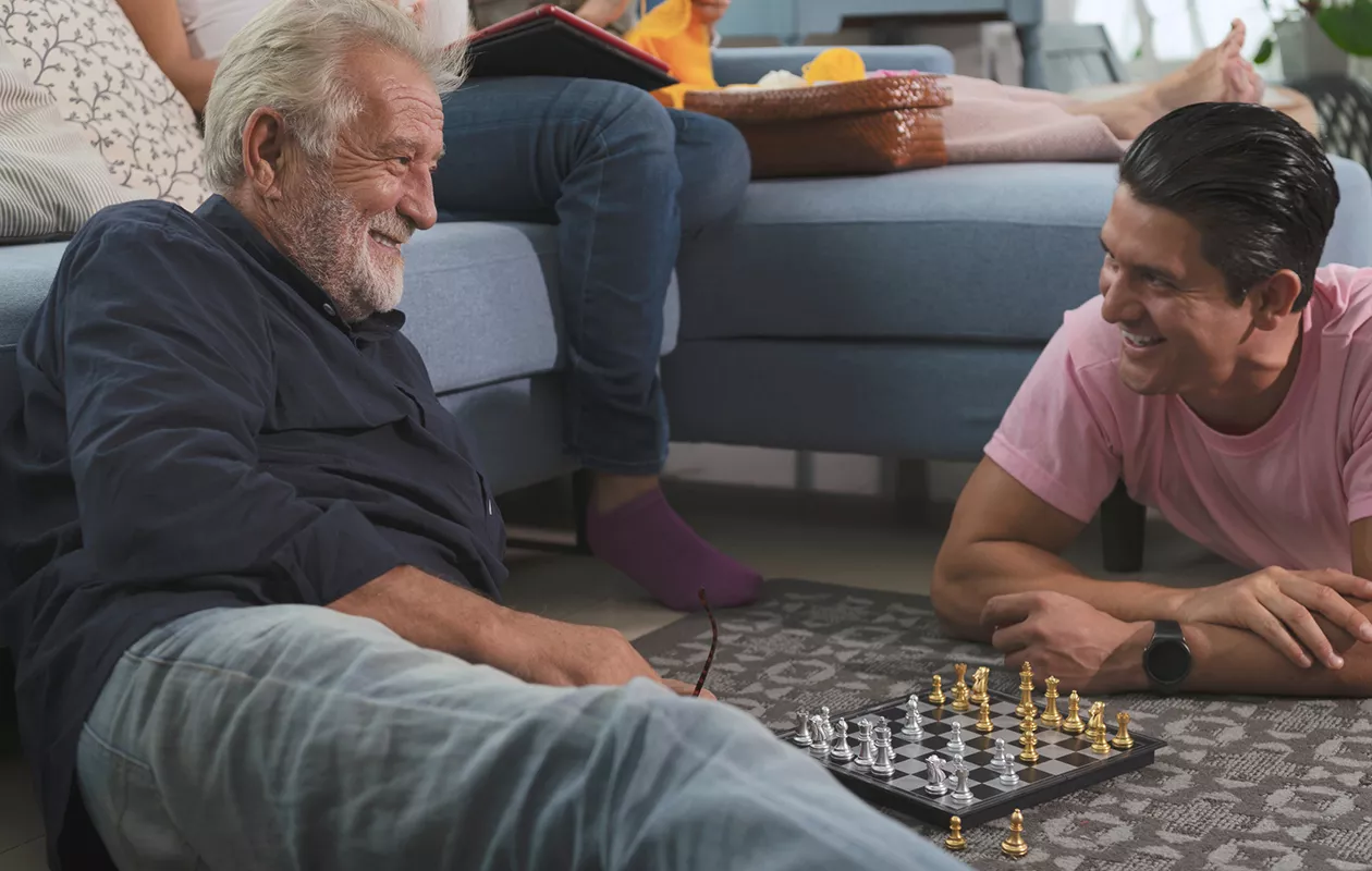 Miten luoda syvempi suhde vanhempiin tai sukulaisiin aikuisiällä? Kuvassa isä ja poika pelaavat shakkia.