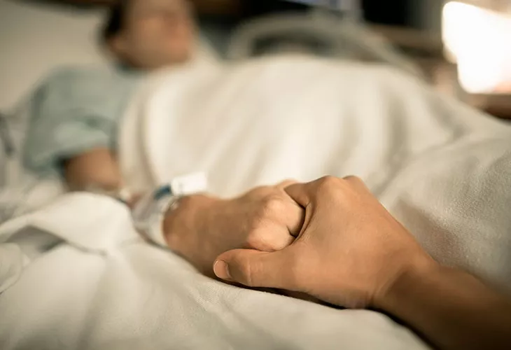 Kuolemanpelko nostaa päätä esimerkiksi sairastumisen myötä. Kuvassa sairaalassa oleva henkilö pitää toista ihmistä kädestä kiinni. 
