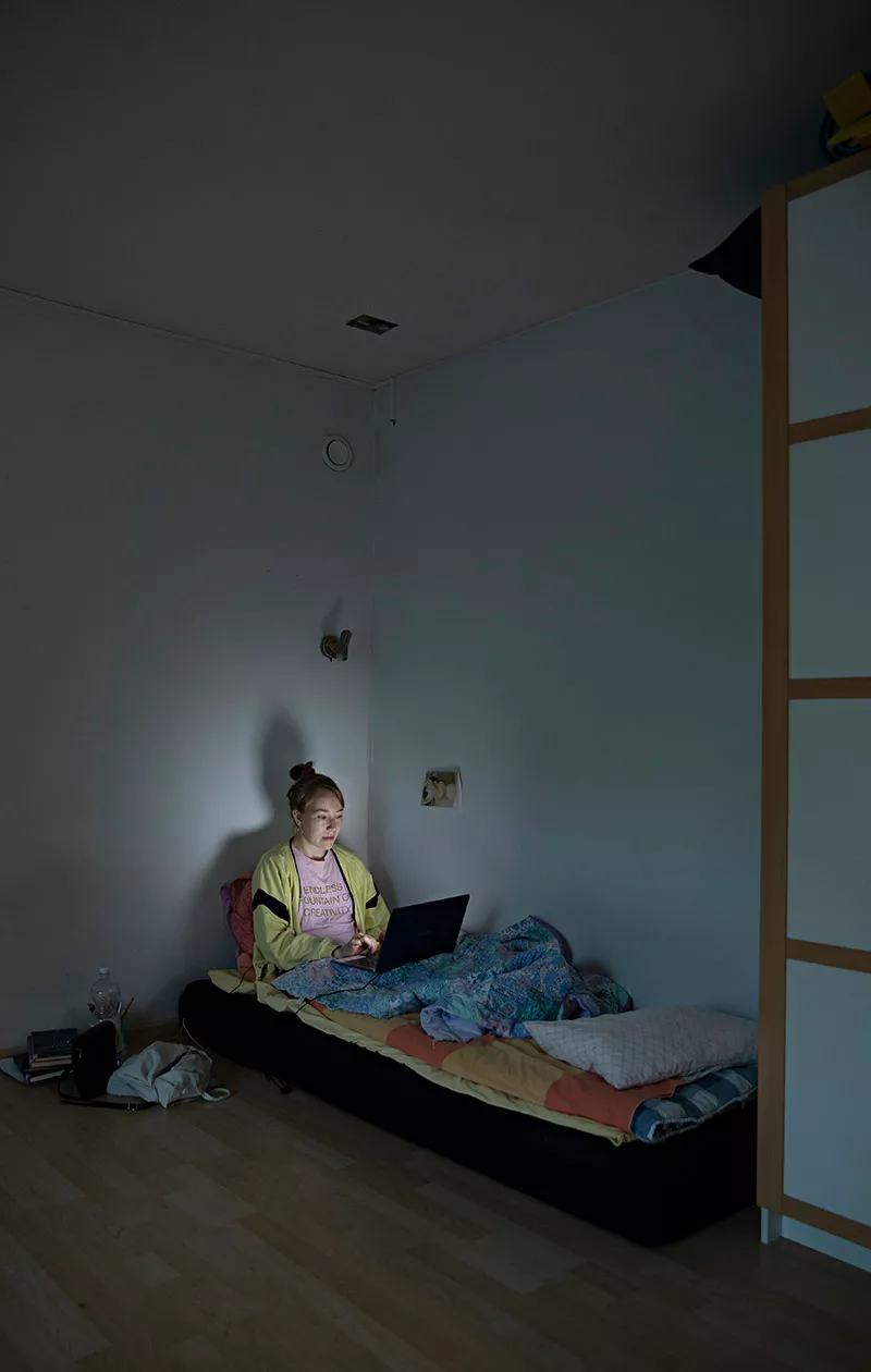 Hanna Storm istuu sängyllä ja tietokoneen näyttö valaisee hänen kasvonsa.