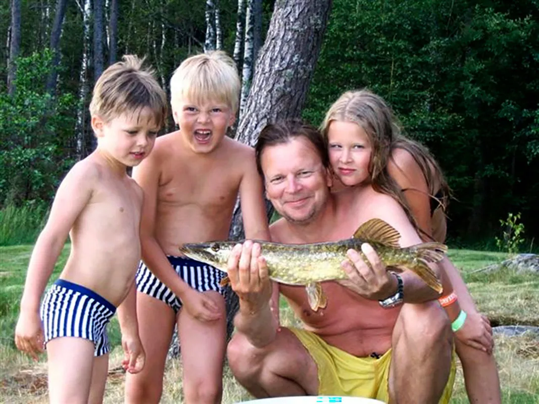 Alex, Oskar, Jari ja Milla. Jari pitää suurta kalaa käsissään.