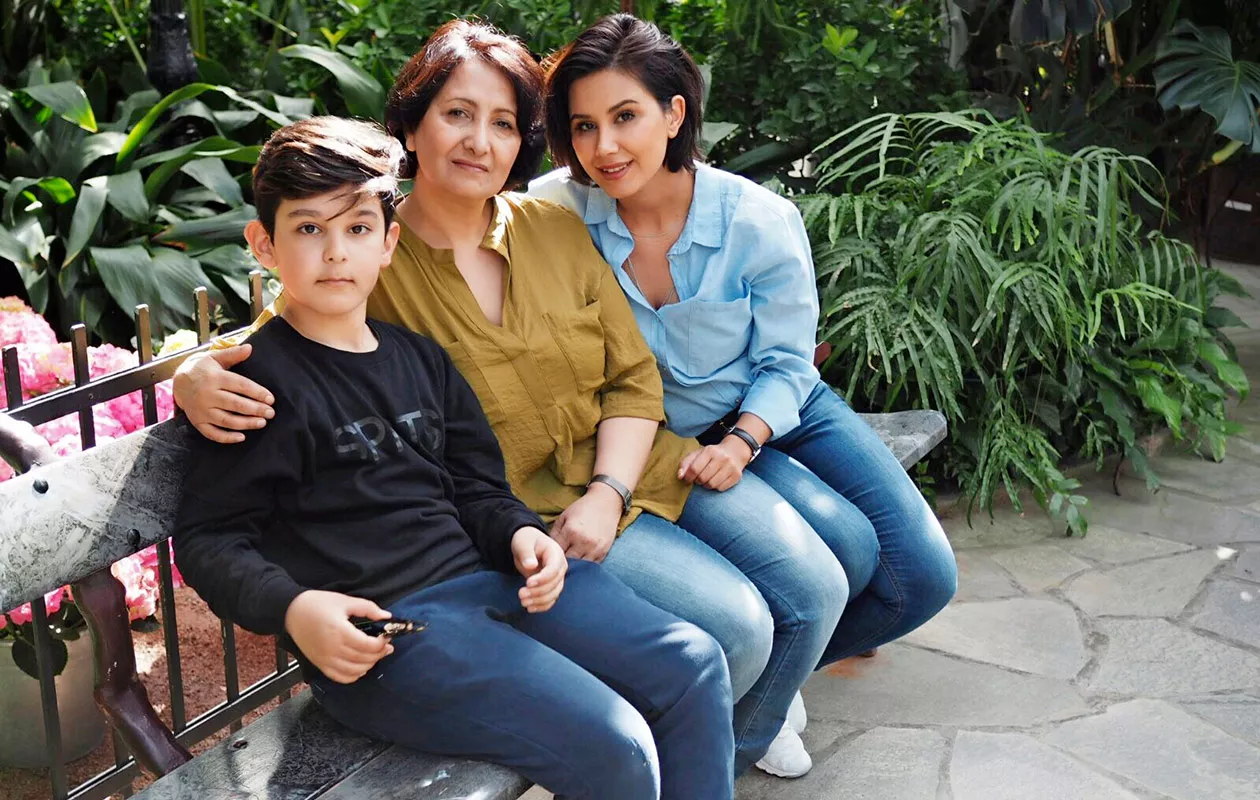 Gelawej istuu penkillä poikansa ja äitinsä kanssa.