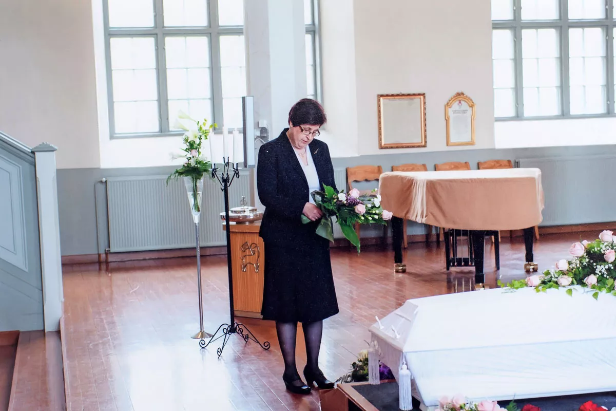 Eeva Nurminen hautajaisissa arkun äärellä. 
