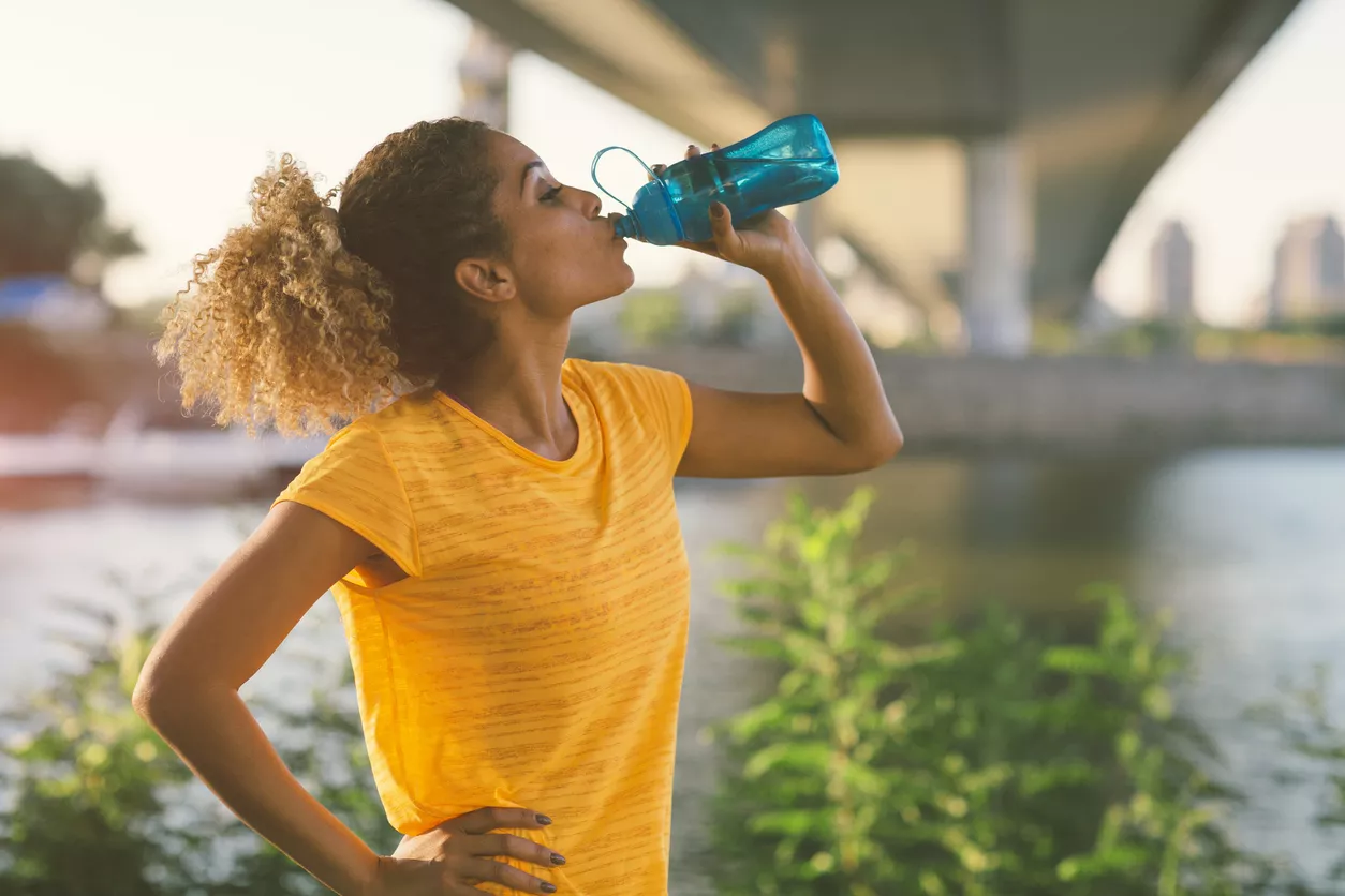 Nainen luo vettä kesken juoksulenkin: veden runsas juominen voi ehkäistä sitä, että suonenveto iskee.