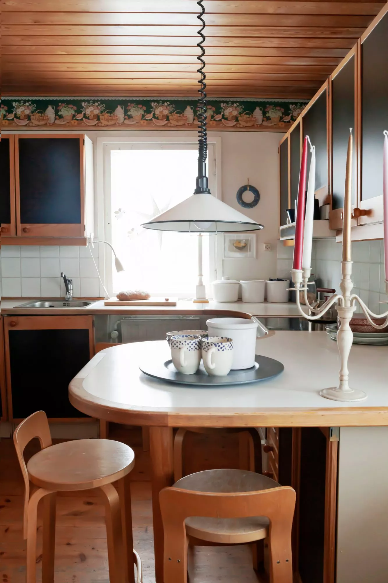 Pienen aamiaispöydän ääressä juodaan päivän ensimmäiset kahvit. Baarijakkarat hankittiin taloon remontin yhteydessä aikoinaan Rovaniemellä toimineesta huonekaluliike Aslakista, joka oli alueen ainoa designliike monia vuosikymmeniä. 