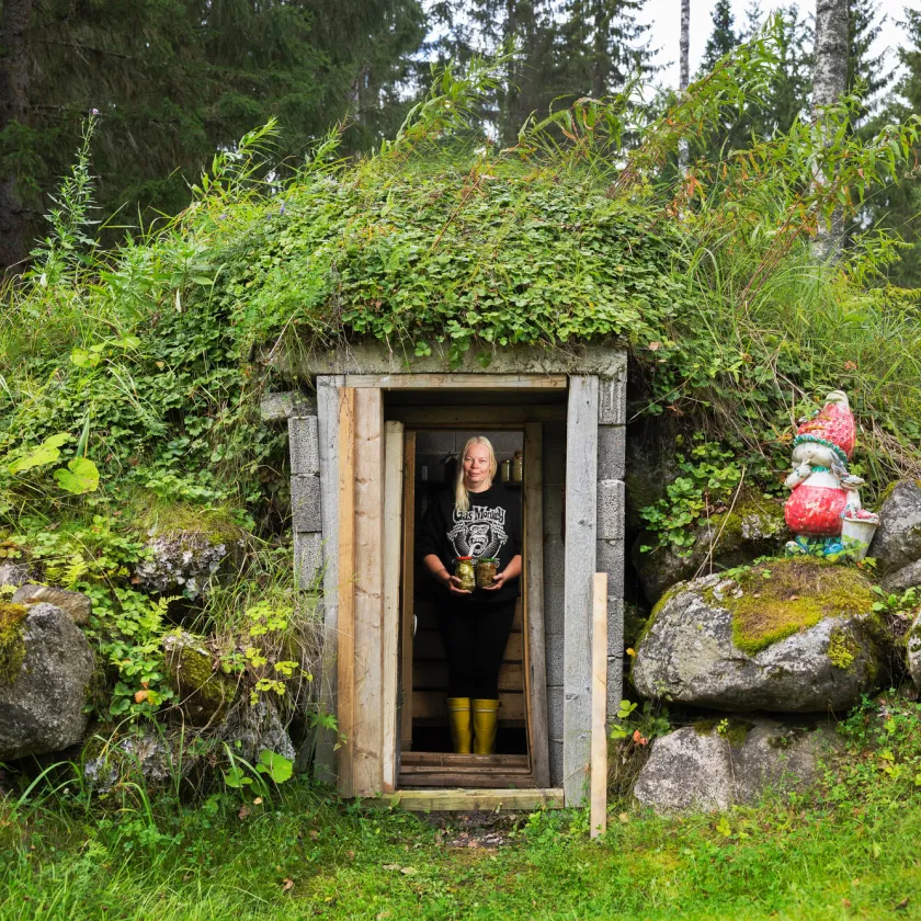 Säilöntä. Marjut Kauppinen seisoo maakellarinsa suulla.