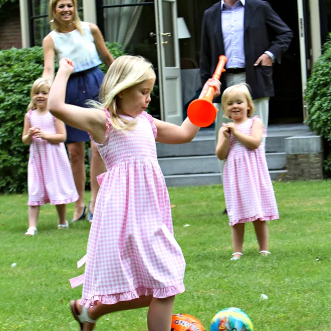 Palloa potkiva Amalia sekä pikkusiskot Alexia ja Ariane vanhempineen virallisessa valokuvassa vuonna 2010. Kuninkaalliset lapset puetaan edelleen usein samanlaisiin asuihin.