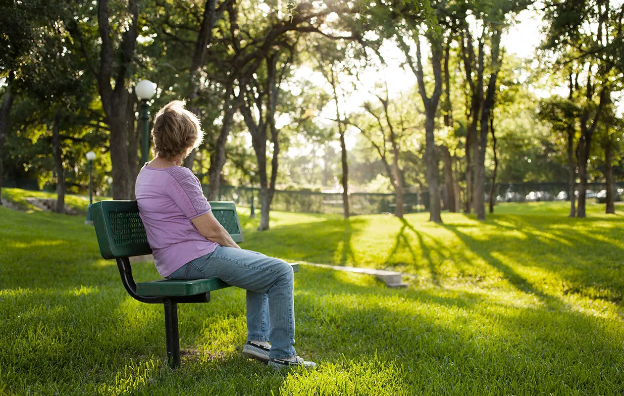 Vaikea äitisuhde voi olla raskas taakka, mutta taakkaa on myös mahdollista keventää, yksinkin. Kuvassa nainen istuu yksin puistonpenkillä.