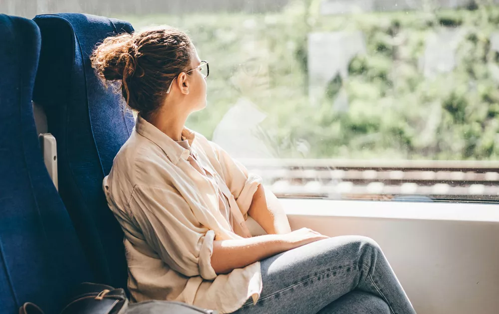 Junamatka: nainen matkustaa junassa.