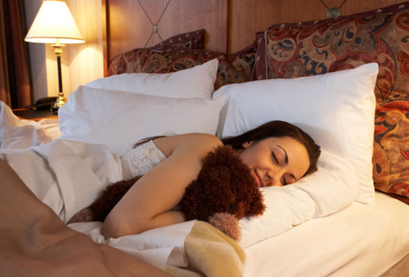 Nainen nukkuu pehmolelun kanssa